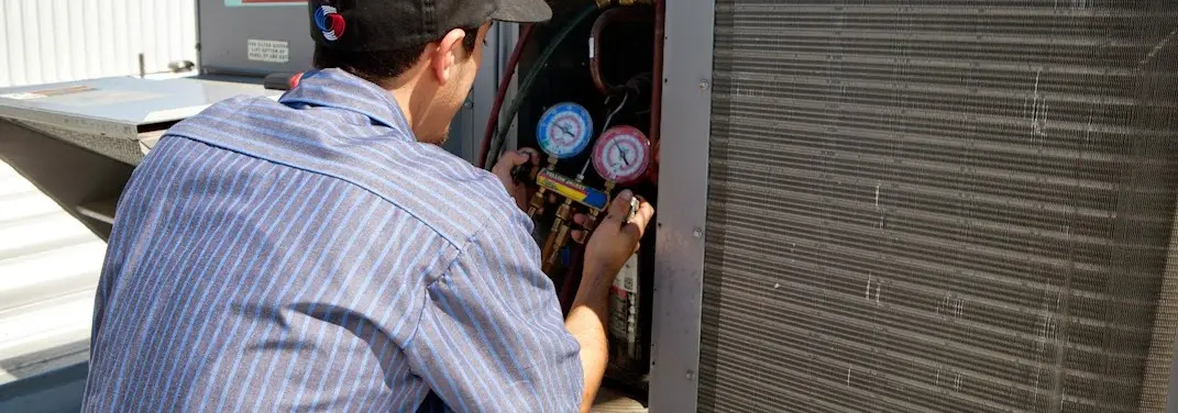 HVAC technician servicing a condenser unit in Viera West